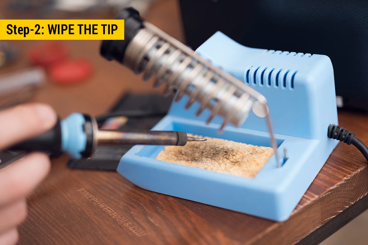 Man cleaning soldering iron tip