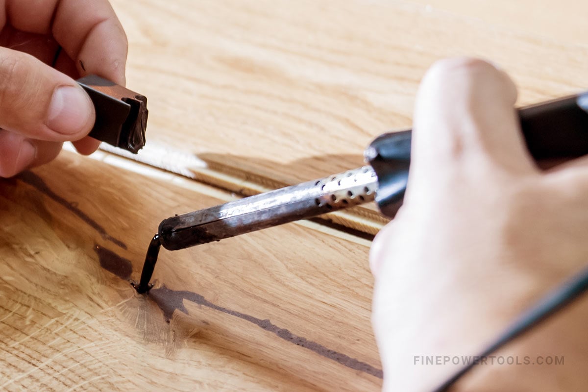 Carpenter using soldering iron on wood