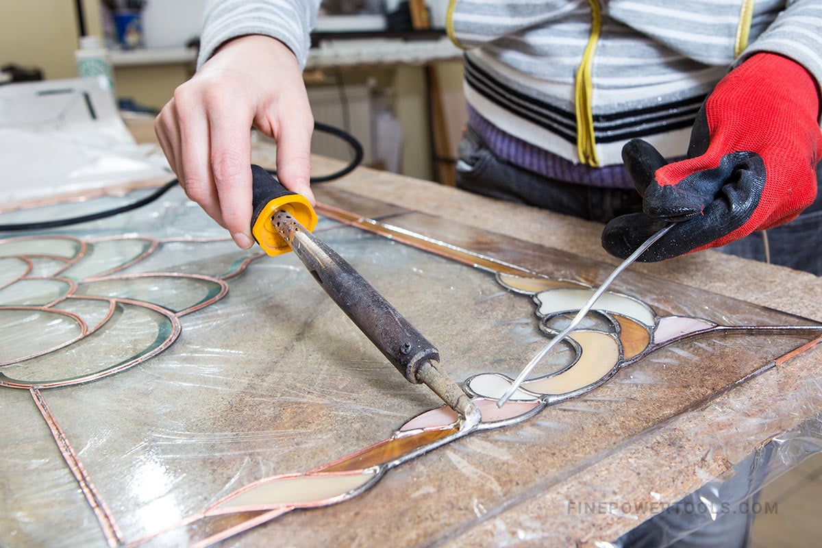 Stained glass maker working with Soldering iron