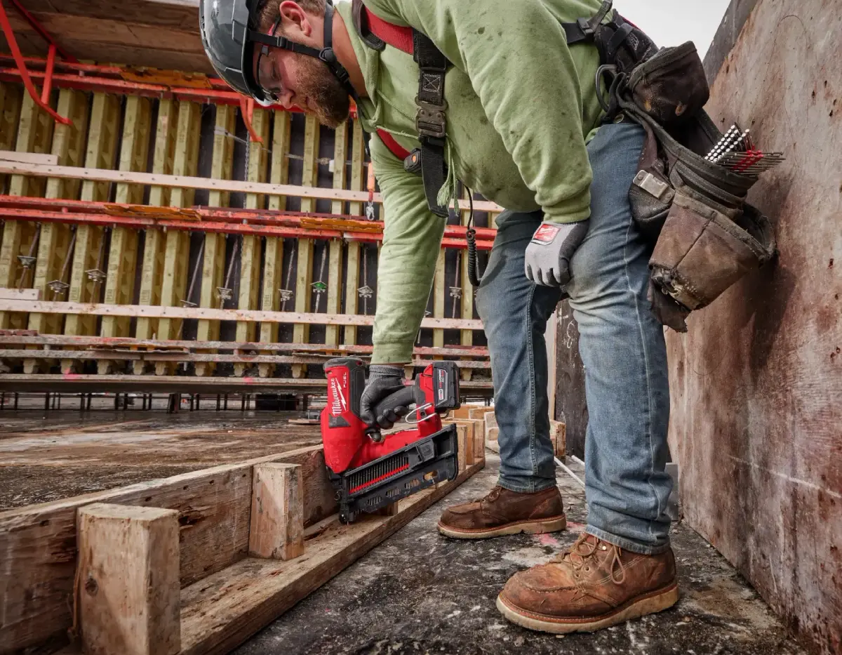 Contruction worker using Milwaukee Duplex Nailer for concrete frame assembly.